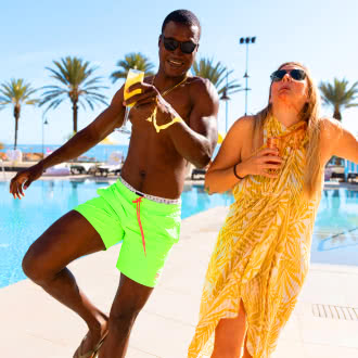 a man and a woman standing next to a swimming pool