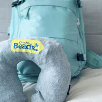 a backpack sitting on top of a bed next to a pillow